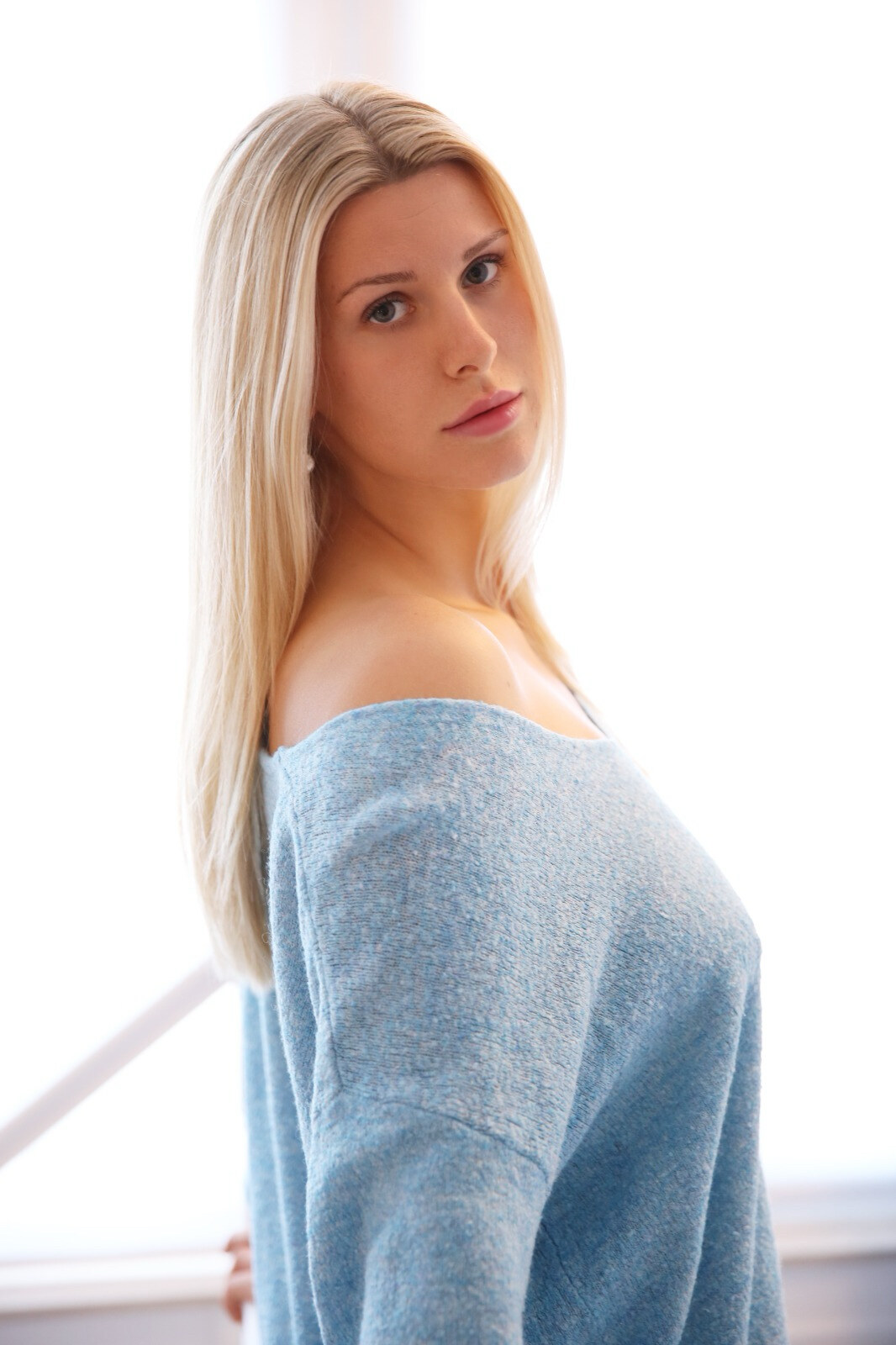 Lucy by a bright window in a pale knit.